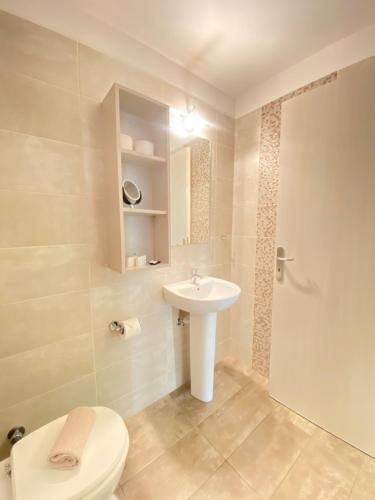 La salle de bains est pourvue de toilettes et d'un lavabo. dans l'établissement Tins Hotel City - Athens, à Athènes