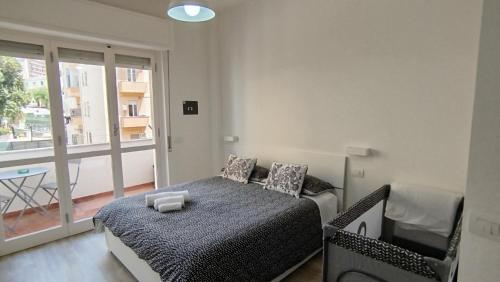 um quarto com uma cama, uma cadeira e uma janela em Town Center Apartment em Cagliari