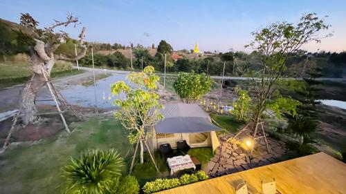 an overhead view of a park with a tent and a pond at บ้านไร่ฟ้าสวยวังน้ำเขียว Nordic 01 in Ban Kom