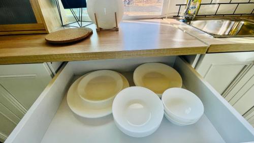 a kitchen with four white dishes in a drawer at บ้านไร่ฟ้าสวยวังน้ำเขียว Nordic 01 in Ban Kom