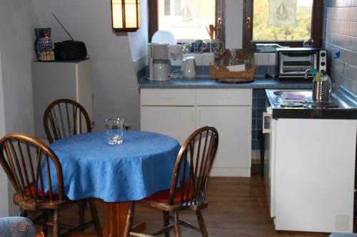 een keuken met een tafel met een blauwe tafeldoek erop bij FeWo Erle - Ulenhoef in Prerow