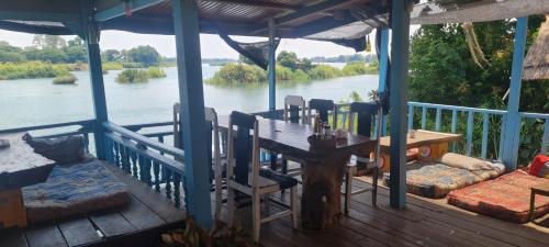 Tena Bangalow 1&2 في Nakasong: شرفة مع طاولة وكراسي وإطلالة على النهر