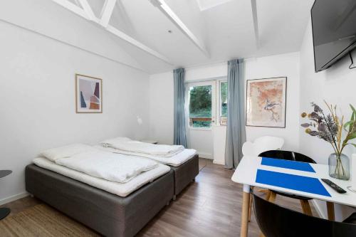 a bedroom with a bed and a desk in it at Holiday Apartment At Beautiful Solgaarden 6 in Svaneke