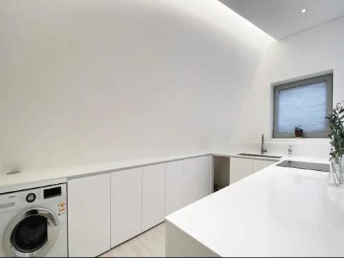 a white kitchen with a washing machine in it at Private duplex house with a nice rooftop - Foreigner only in Seoul