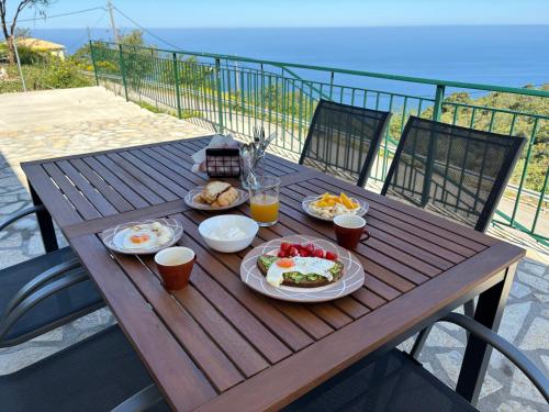 a wooden table with plates of food and drinks on it at Anemar Lefkada in Drymon