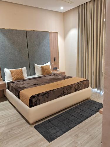 a bedroom with a large bed with a large window at Hotel imperia in Kharar