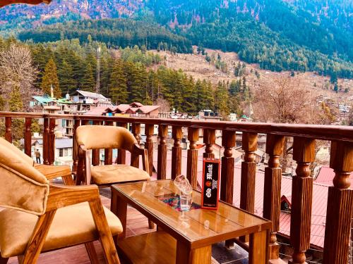 un tavolo e due sedie su un balcone con vista di Sawdesh hotel a Vapi