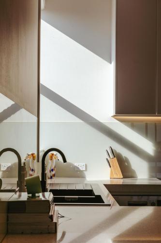 a kitchen with a light shining through a window at Paris End of St Kilda Apartment in Melbourne