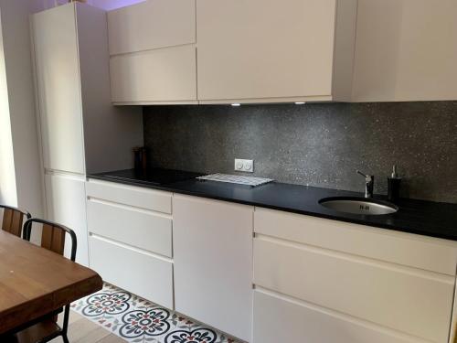 une cuisine avec des armoires blanches et un évier dans l'établissement 2 chambres et une terrasse à Paris!, à Paris