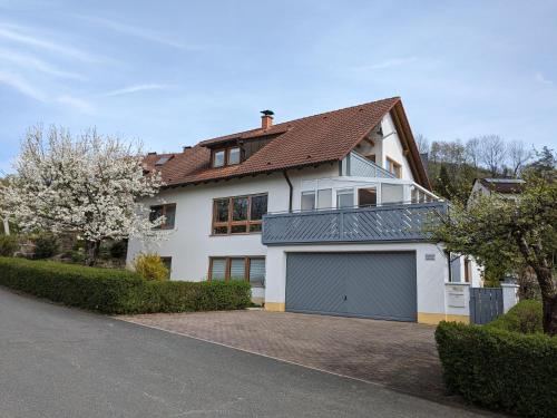 a large white house with a garage at Ferienwohnung am Rotdornweg in Heiligenstadt