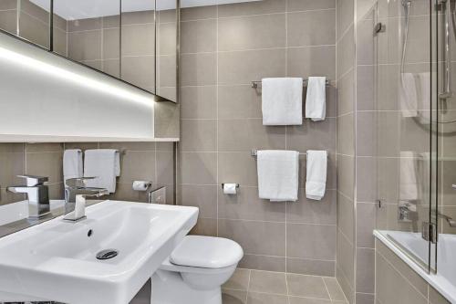 uma casa de banho com um lavatório, um WC e um espelho. em Amazing two bedroom St Leonards ATC62010 em Sidney