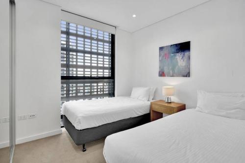 een slaapkamer met 2 bedden en een raam bij Amazing two bedroom St Leonards ATC62010 in Sydney