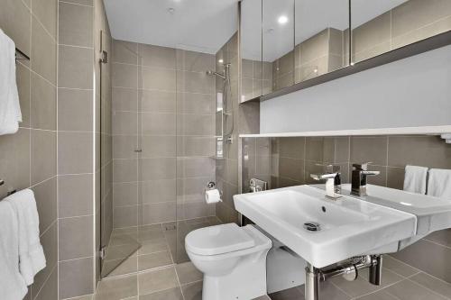 La salle de bains blanche est pourvue d'un lavabo et de toilettes. dans l'établissement Amazing two bedroom St Leonards ATC62010, à Sydney