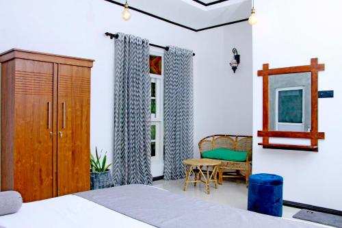 - une chambre avec un lit, une armoire et une chaise dans l'établissement Lilu Villa Walana Weligama, à Weligama