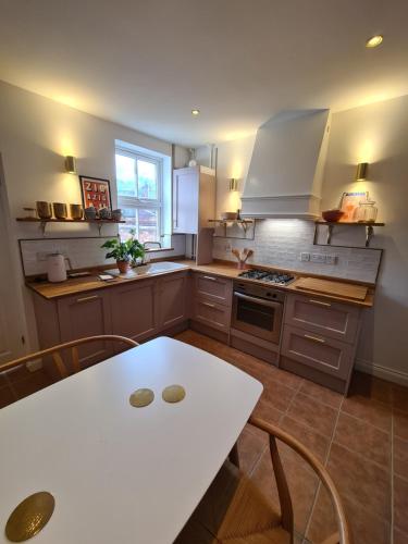 a kitchen with a white table and a white table at City Cottage in Lincoln