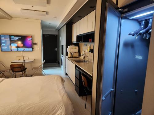 Daegu Dongseongro Star B&B business hotel في دايغو: غرفة صغيرة بها سرير ومطبخ