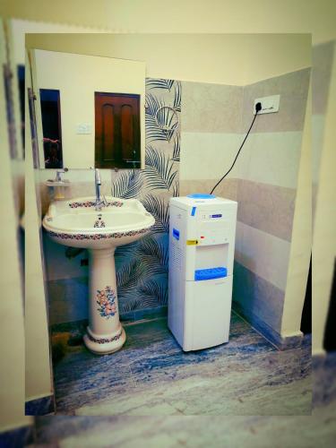 a bathroom with a sink and a small refrigerator at Kashyaam Inn in Varanasi