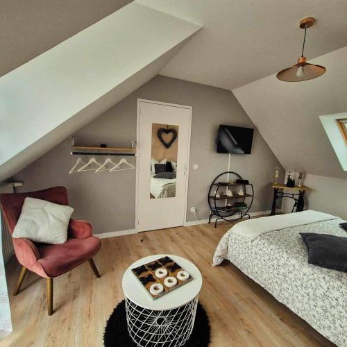 une chambre avec un lit, une table et une chaise dans l'établissement Les Charmilles, à Escoville