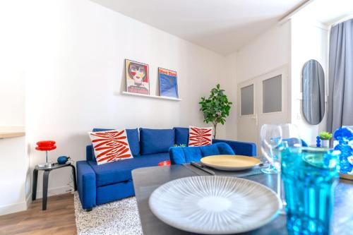 un salon avec un canapé bleu et une table dans l'établissement Appartement des Quinconces, à Bordeaux
