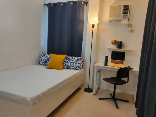 ボラカイにあるRomantic Sunset Apartment with Balcony 2 min Walk to the Beachのベッドルーム1室(ベッド1台、ノートパソコン付きのデスク付)