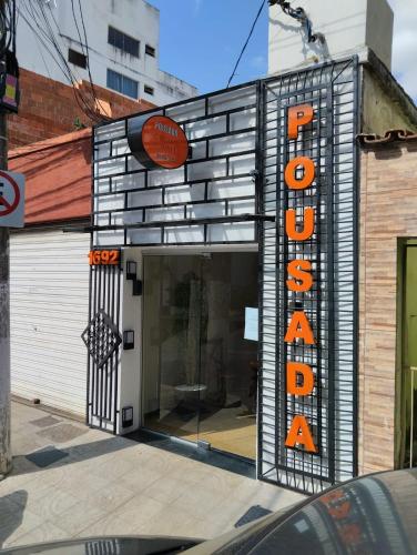 a store with a sign on the side of a building at SUITE 15 para Casal e 2 crianças - POUSADA CRISTAIS DO VALE in Teófilo Otoni