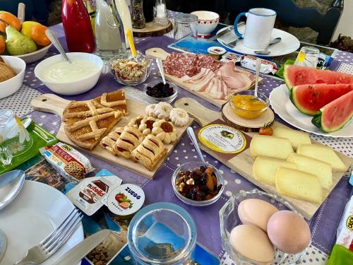 a table with cheese and other foods on it at LA GINESTRA B&B in Fosdinovo