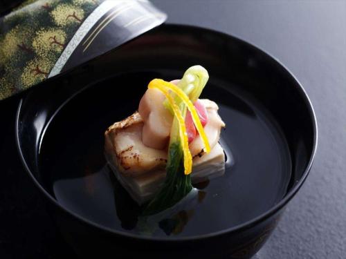 a black bowl with a piece of food on it at Hotel New Wakasa in Nara