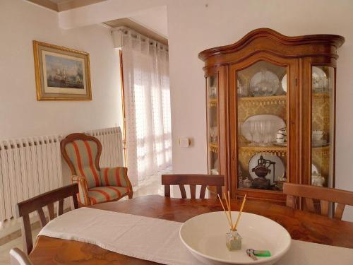 a dining room with a table and a china cabinet at Grande Appartamento in Villa con 2 camere, terrazze, giardino, barbecue e posto auto privato Tutti spazi uso esclusivo in Cecina