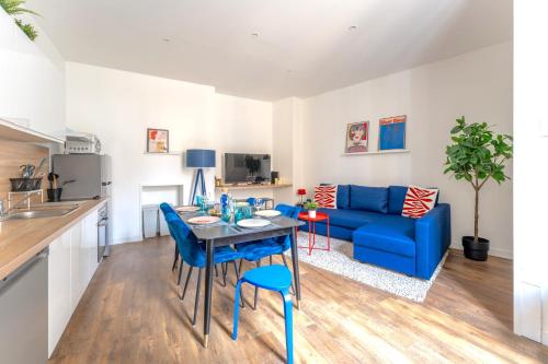 un salon avec un canapé bleu et une table dans l'établissement Appartement des Quinconces, à Bordeaux