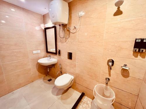 a bathroom with a toilet and a sink at Sarlod Guest house in Vapi