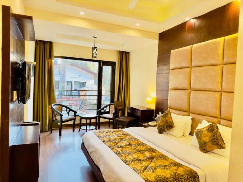 a hotel room with a bed and a table and chairs at Sarlod Guest house in Vapi