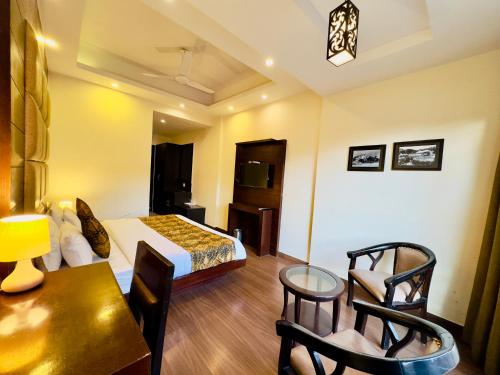 a hotel room with a bed and a table and chairs at Sarlod Guest house in Vapi