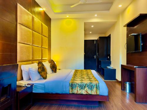 a hotel room with a bed and a television at Sarlod Guest house in Vapi