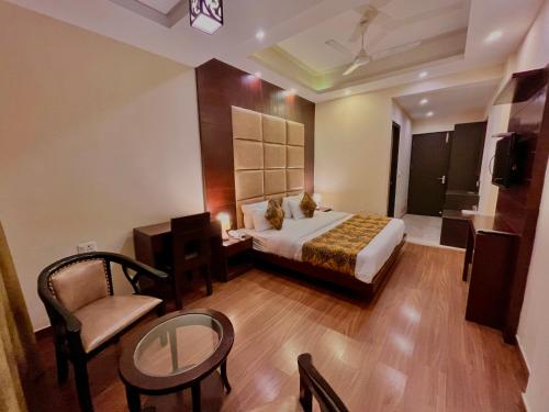 a bedroom with a bed and a chair and a table at Sarlod Guest house in Vapi