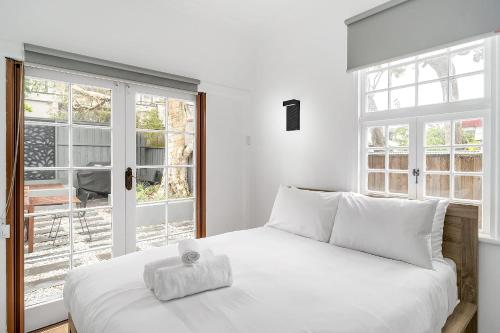 Un dormitorio con una cama blanca con una toalla. en Balmain Beauty - Spacious Garden en Sídney