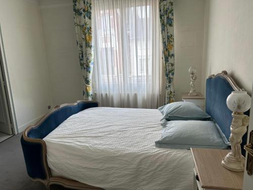 um quarto com uma cama com uma moldura azul e uma janela em Appartement AUMALE em Aumale