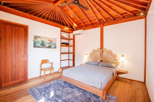 Un dormitorio con una cama y un techo de madera. en Mini Villa, en Munggu