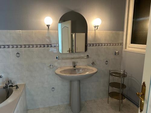 uma casa de banho com um lavatório e um espelho em Appartement AUMALE em Aumale