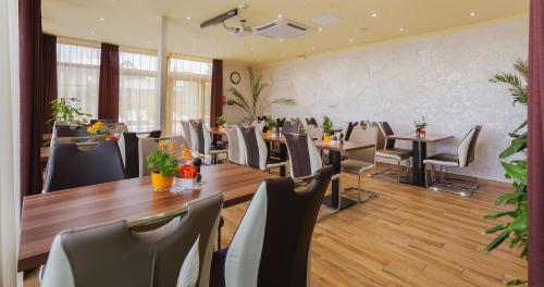 a restaurant with tables and chairs in a room at Hotel Mayer Alsóörs in Alsóörs