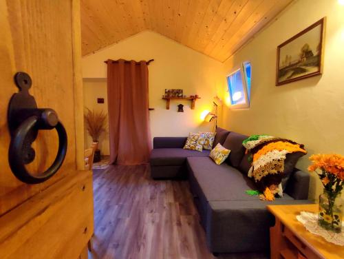 una sala de estar con un sofá azul en una habitación en Tinyfarm "Stará Láska" - Holidayfarm Natural Slovakia, en Modrý Kameň