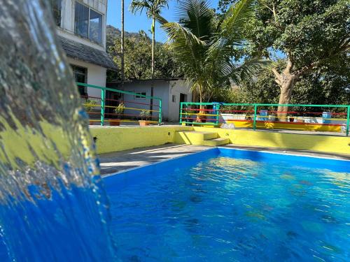 Tapovan Villa & Resort في بيون: مسبح بمياه زرقاء امام مبنى