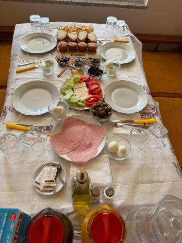 a table with plates and food on it at Qyteza Guest House & Camping in Shkodër