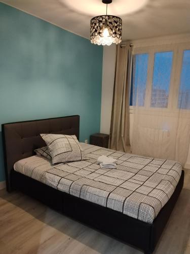 une chambre avec un grand lit avec un mur bleu dans l'établissement Appartement entier, à Montpellier