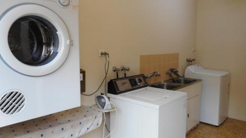 a washer and dryer in a bathroom with a washing machine at Dunbar Court Unit 4 - 45 Memorial Avenue South West Rocks in South West Rocks