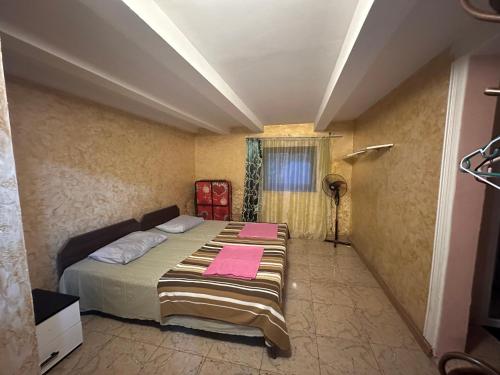 ein Schlafzimmer mit einem Bett mit rosa Handtüchern darauf in der Unterkunft Emilis Vacation Home in Kobuleti