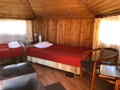een slaapkamer met 2 bedden in een houten hut bij Etm Lodge 