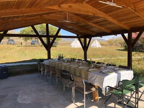 a long table and chairs under a wooden pavilion at Etm Lodge 