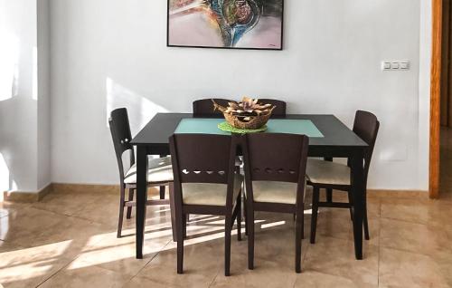 - une table à manger noire avec des chaises et un panier dans l'établissement Pet Friendly Apartment In San Javier With Kitchen, à San Javier