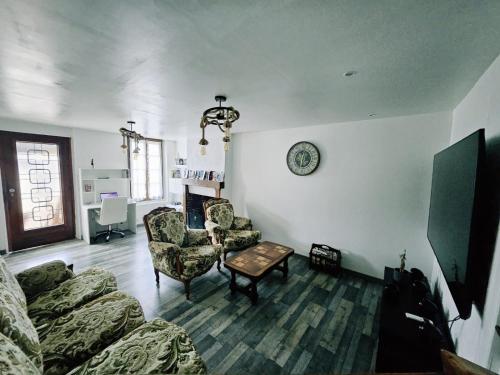 a living room with a couch and chairs and a table at Gîte de Montapeine 8 in Breteau