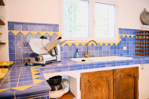 une cuisine carrelée bleue avec un mélangeur sur un comptoir dans l'établissement Maison d'Architecte * 2 piscines *, à Saint-Saturnin-lès-Avignon